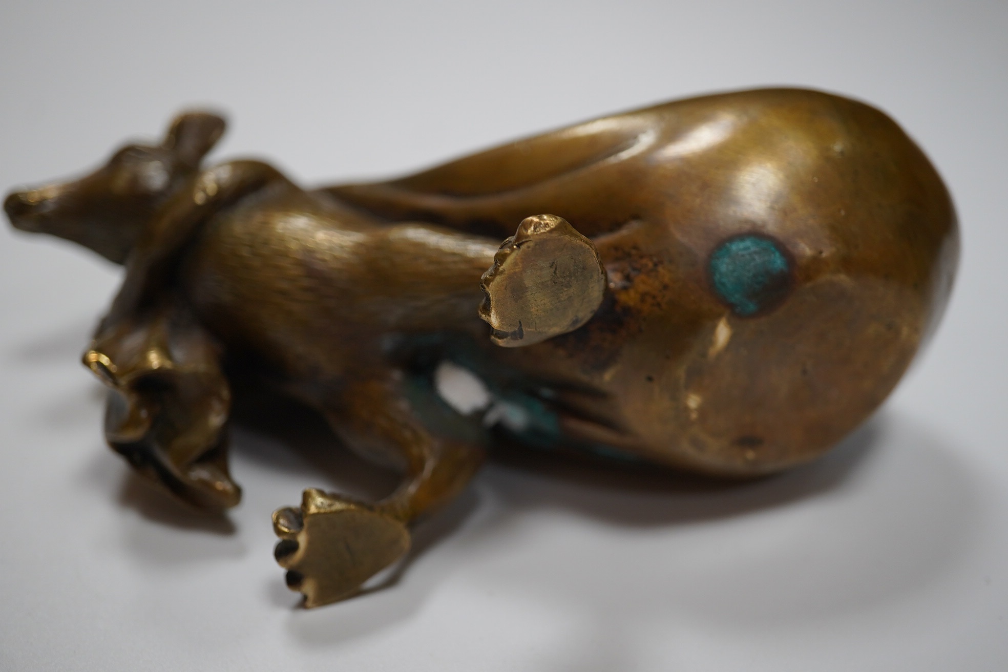 A Chinese bronze rat carrying a sack, signed in casting, 14cm long. Condition - fair